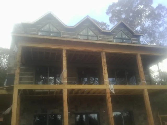 Dormers and porch framing on a large log home under construction — Roof Coating work by our crew in Colville