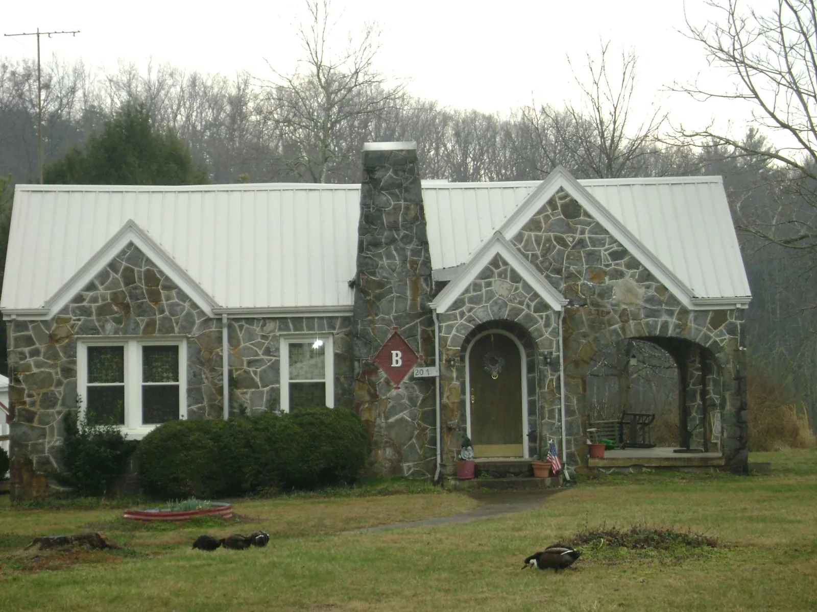 White metal roof on a stone cottage with steep gables in Colville