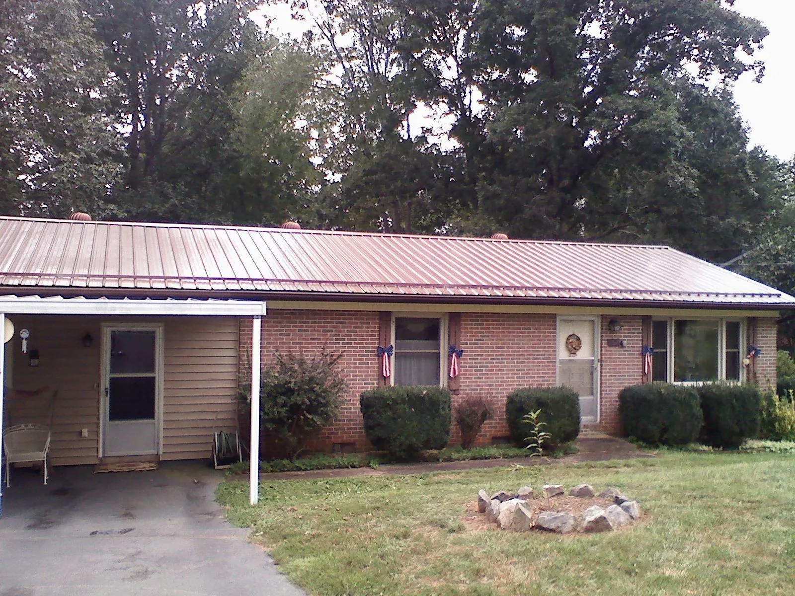 Bronze metal roof and carport on a brick ranch home — Roof Repair work by our crew in Colville